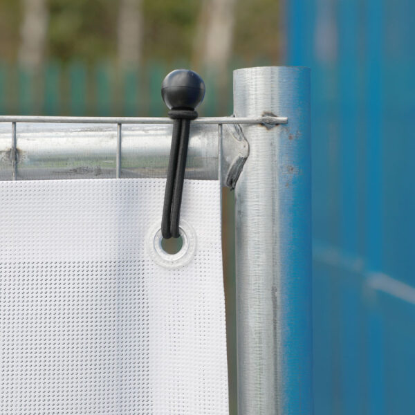 Close-up of a white Heras fencing banner attached to a galvanised temporary fence panel using a black bungee cord and eyelet fastening.